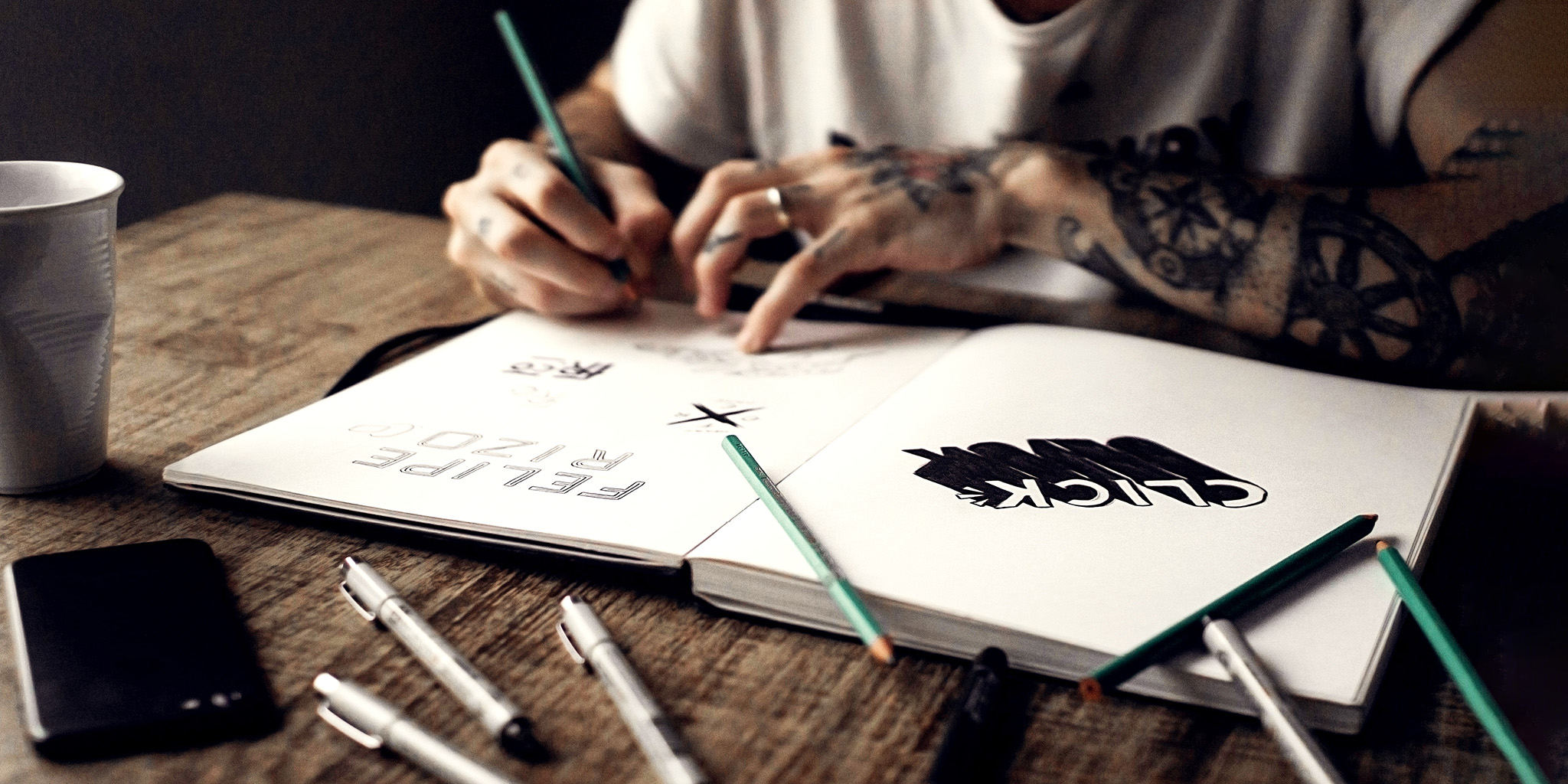 Man or woman sketching in a sketchbook notebook, sketching logos, logo design